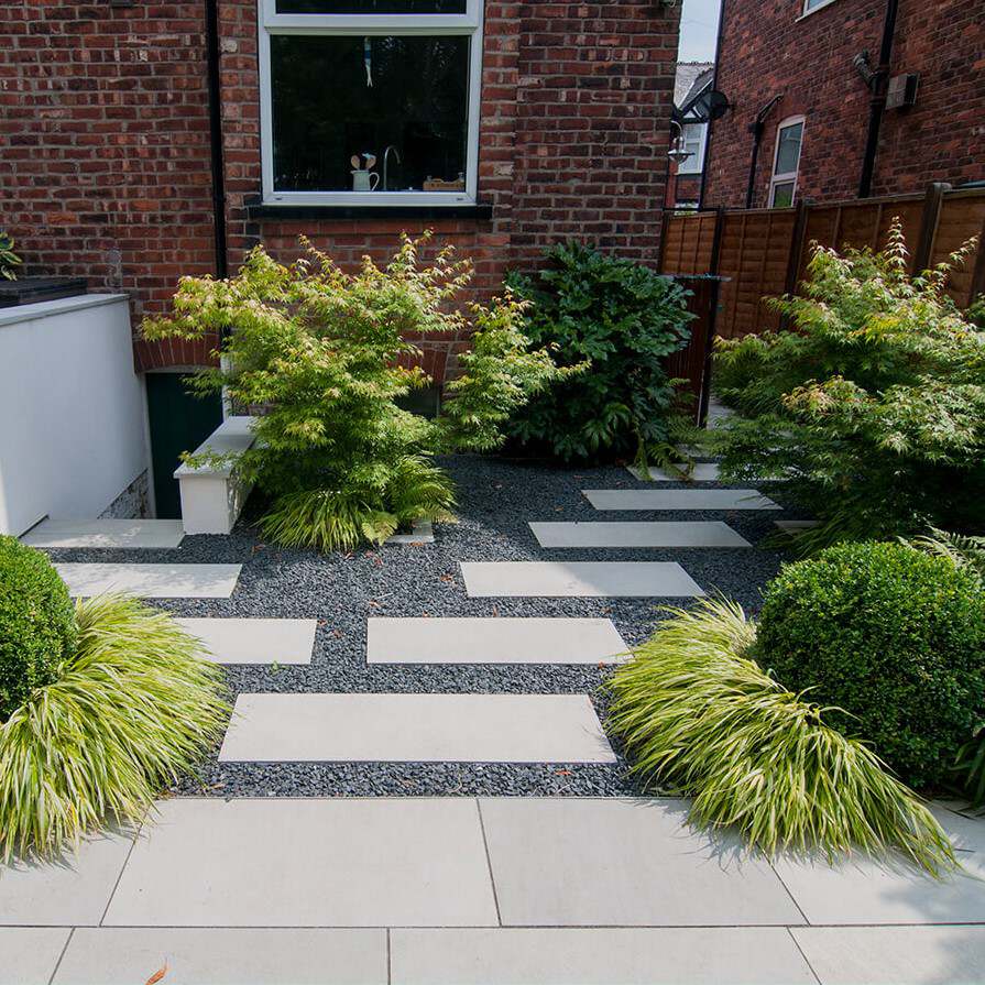 Light basalt slabs and black gravel forming a small courtyard garden