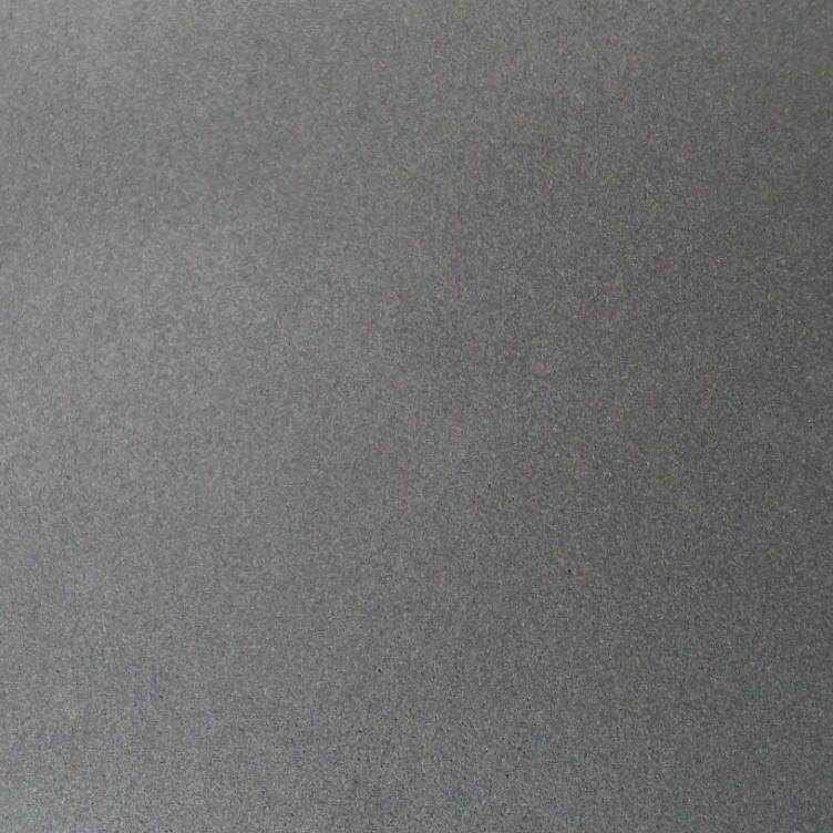 Honed black basalt tile, close-up of the even dark grey grain